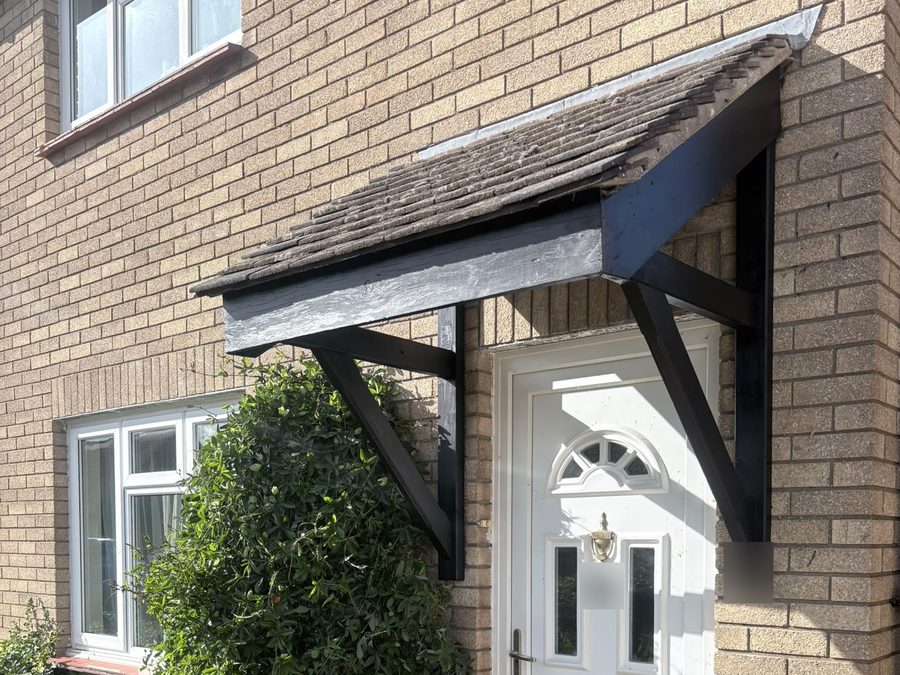 Door canopy with replacement timbers, repainted black